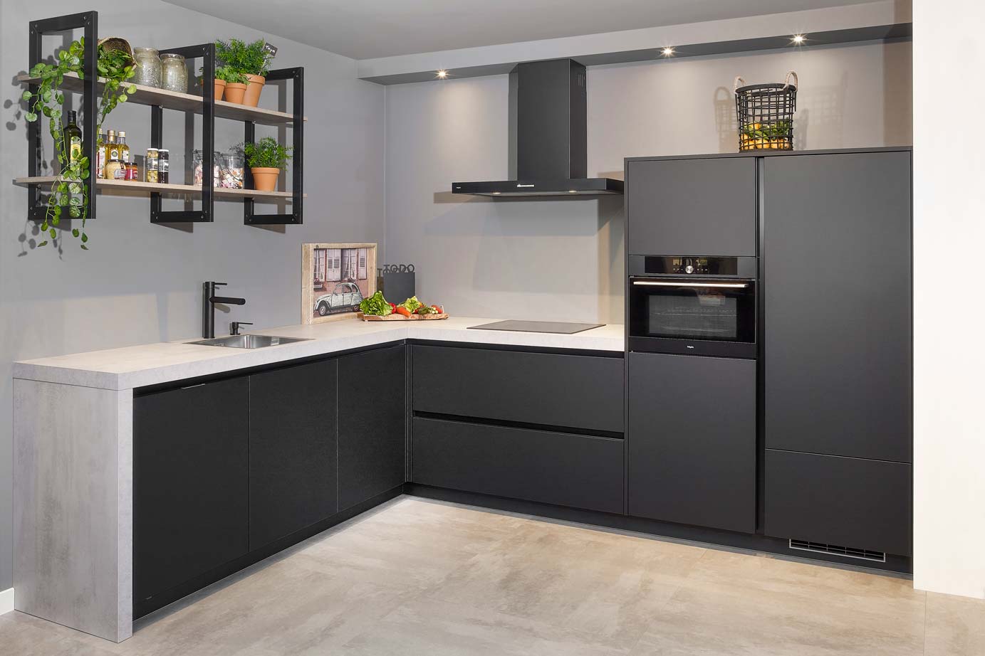 Moderne keuken industrieel met zwarte greeploze fronten en betonlook werkblad