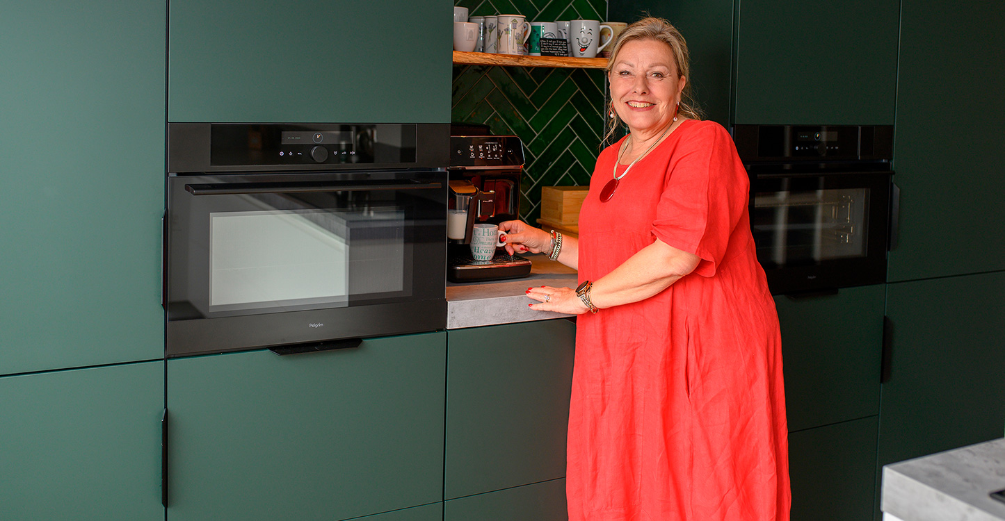 Groene hoekkeuken met kastenwand en ingebouwde koffiecorner