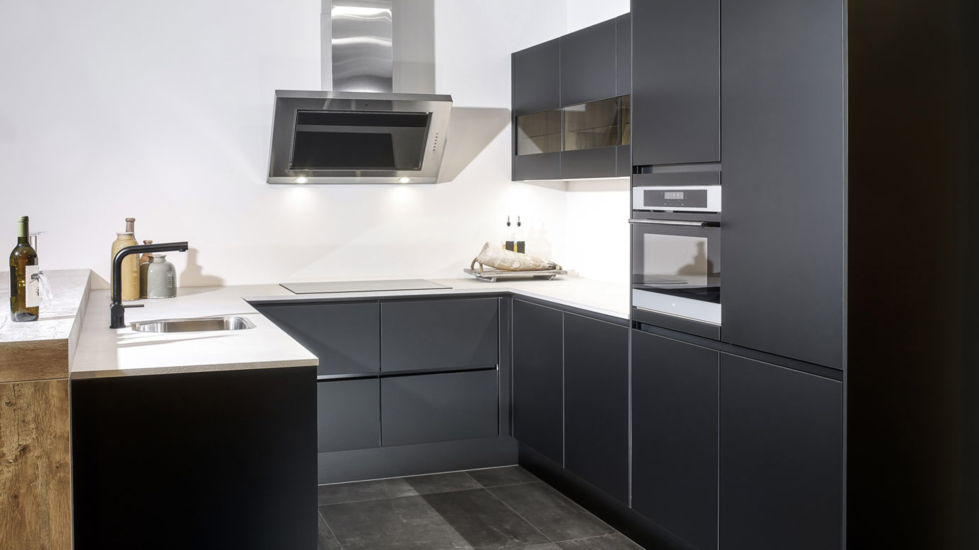 Deze zwarte moderne u-keuken heeft een bar in houtlook