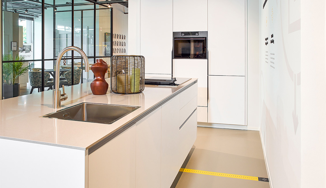 Ergonomische keuken met wit keukeneiland, houten details en een strak ontwerp voor optimale functionaliteit.