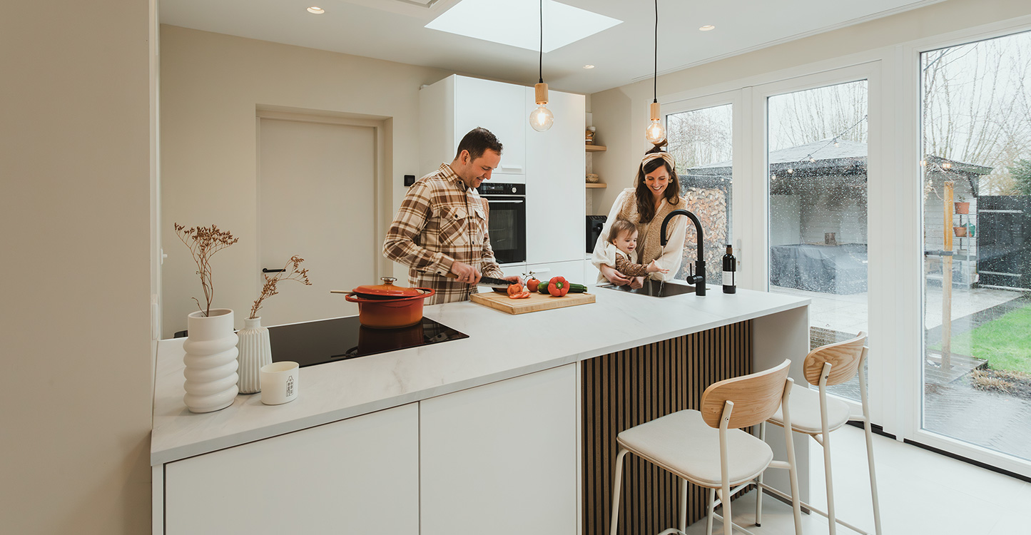 Familie Pieper en dochter in witte moderne keuken met schiereiland en inductiekookplaat 