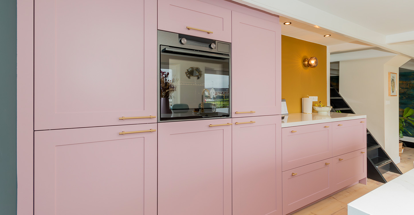 Roze kastenwand in moderne kleurrijke keuken