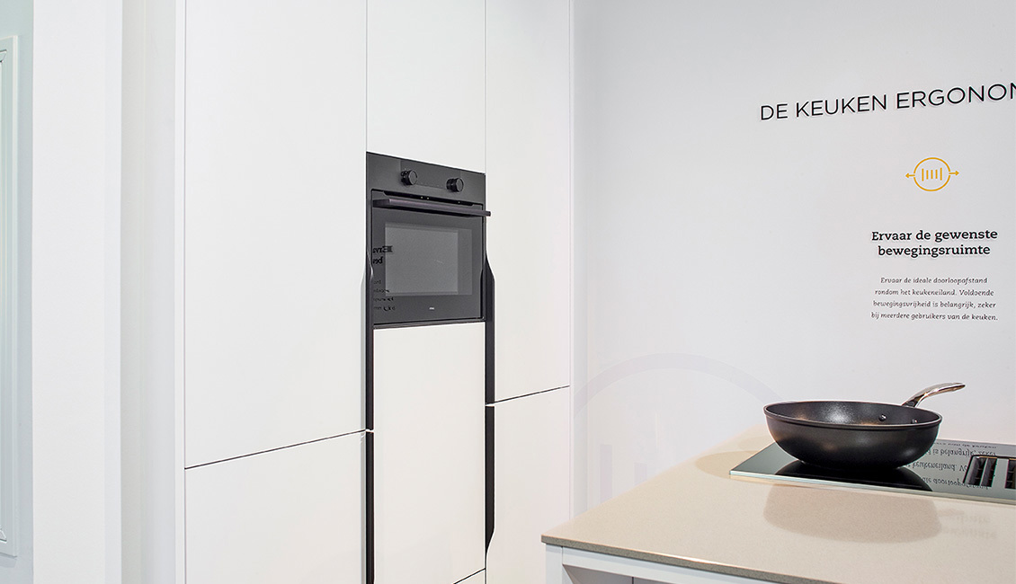 Ergonomische keuken met wit keukeneiland, houten details en een strak ontwerp voor optimale functionaliteit.