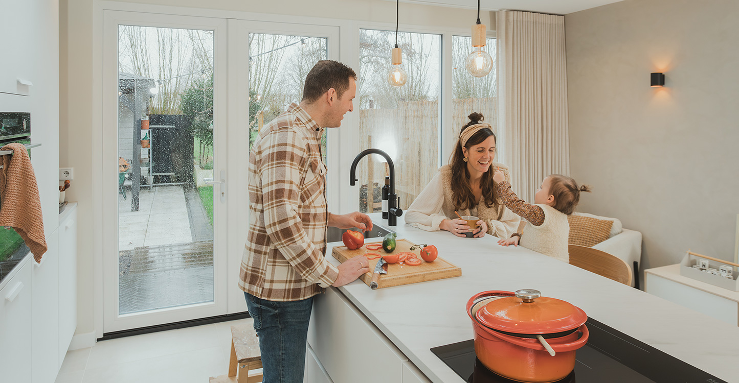 Familie Pieper en dochter in witte keuken, aan het keukeneiland